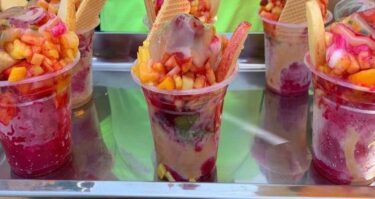 Una copa de cholao valluno casero decorado con frutas y leche condensada.