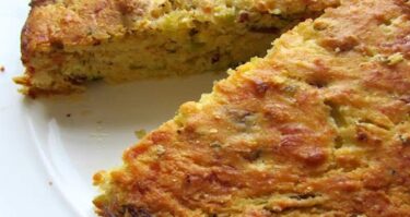 Receta terminada de Pastel de Vegetales con Maní: Deliciosa combinación de pan integral, apio, maní, ajo, queso rallado, perejil, huevos y jugo de tomate en un molde rectangular. Horneado a la perfección para una experiencia culinaria única y saludable.