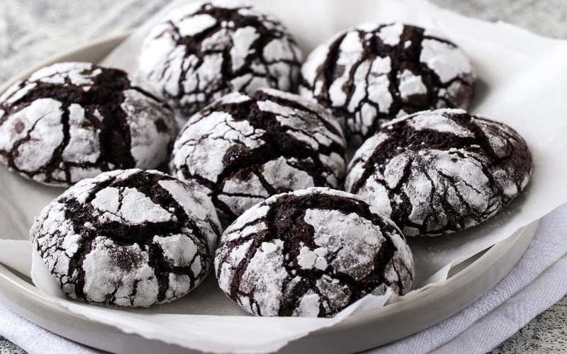 Imagen de deliciosas galletas craqueladas de chocolate recién horneadas, la gula en su máxima expresión.